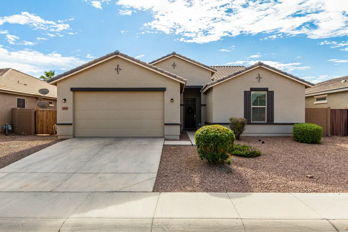 This exterior image showcases the inviting front of the home, including the entryway, landscaped shrubs, and garage door. The front yard is visible, hinting at ample space for children to play or family gatherings to take place.